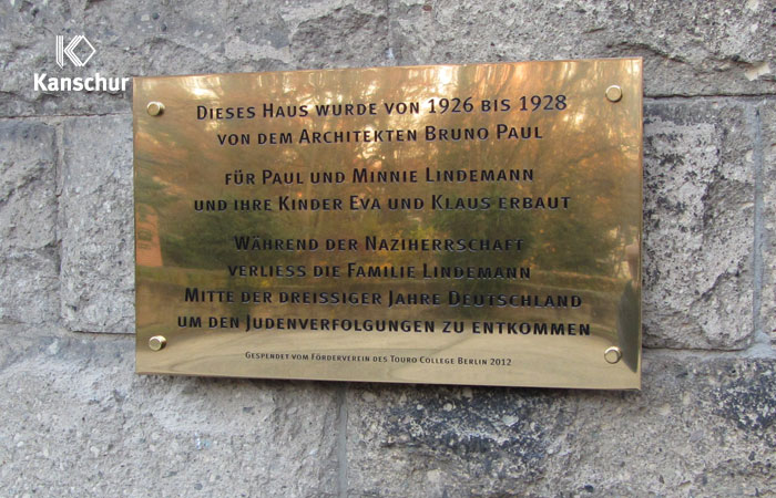 Gedenktafel mit Gravur aus polierten Messing an Natursteinwand mit Abstandhalter befestigt